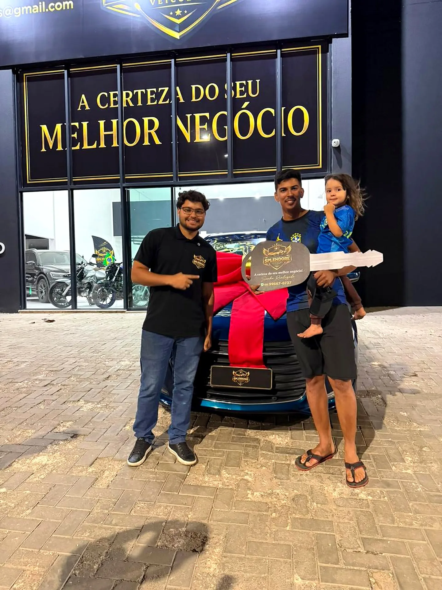 Pai e filha recebendo o veículo com laço na Splendore